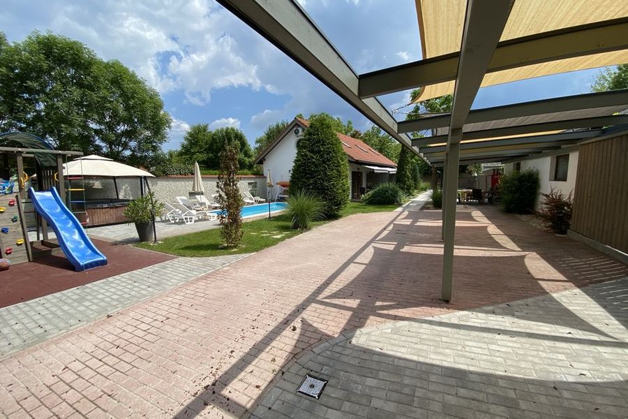 A Siófoki Apartmanok udvara napvitorlákkal, medencével és játszótérrel